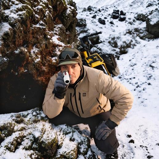Man kijkt met een monoculaire in de bergen tijdens de sneeuw.