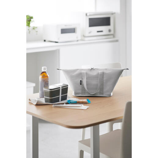 Lichtgrijze Vario-koeltas op een tafel, omringd door snacks en drankjes.