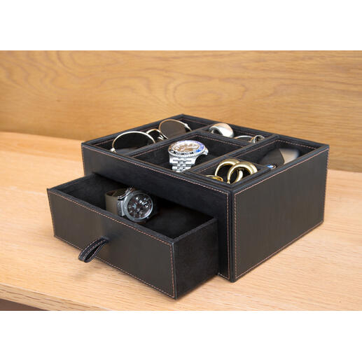 Zwarte leren opbergbox met verschillende accessoires zoals horloges en brillen.