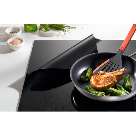 Koekenpan met courgette en een kotelet op een inductiekookplaatbescherming