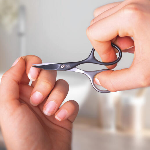 Persoon met zelfslijpende manicure-schaar knipt haar nagel.