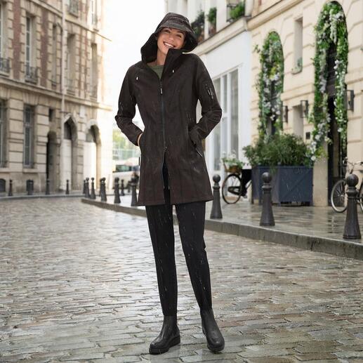 Vrouw in een zwarte Imperméable op een regenachtige straat