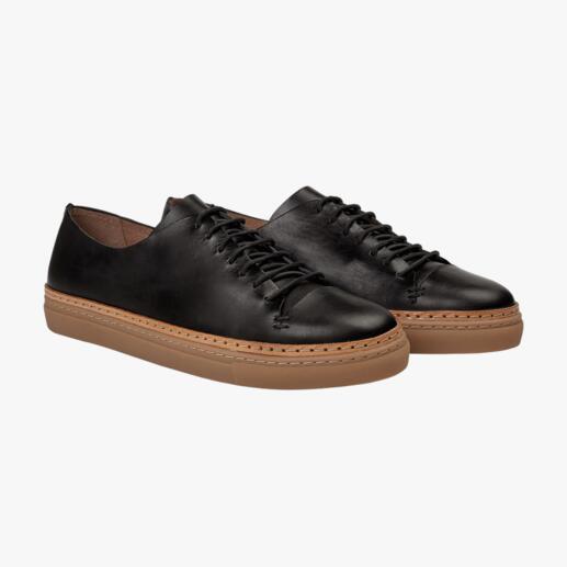 Twee zwarte basic leren sneakers met veters naast elkaar