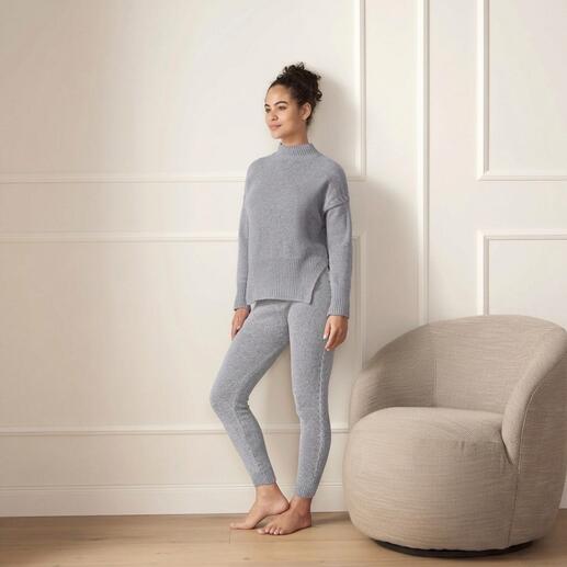 Vrouw draagt grijze merinosweater en leggings in een lichte ruimte