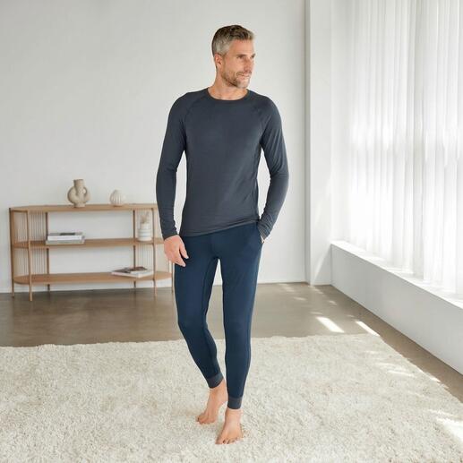 Man in Dagsmejan pyjama, bestaande uit een langhemd en leggings in donkergrijs.