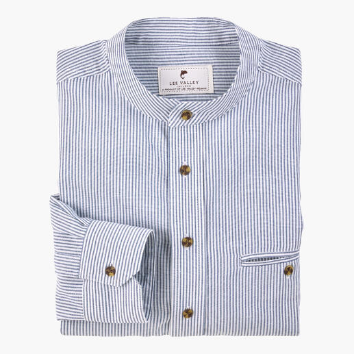 Gestreepte grandfather zondag shirt in blauw en wit, gevouwen op een tafel.