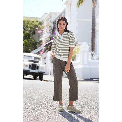 beige Vrouw in gestreept poloshirt en losse broek in een stedelijke omgeving.