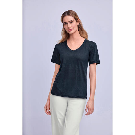 jeansblauw Vrouw draagt een zwarte Edel-Linnen shirt met V-hals.