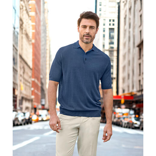 Junghans 1954 piquépolo van zijde Man in een donkerblauw piqué polo, poseert op een straat.