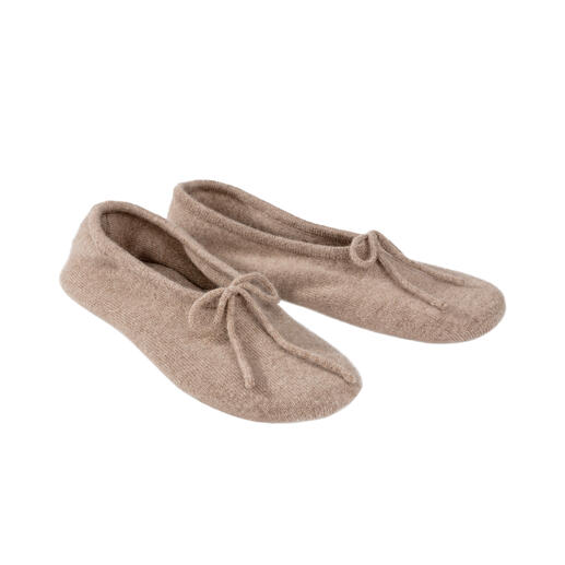 Twee kasjmier reisschoenen in lichtbeige naast elkaar.