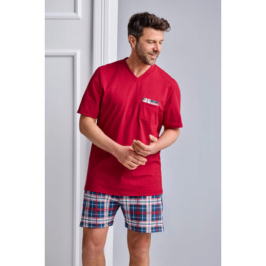 Man draagt een rode pyjama met blauwe en witte geruite shorts.