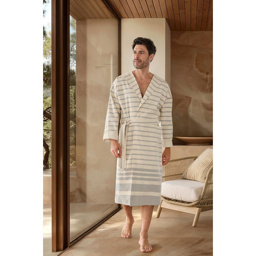 heren Man in een gestreepte hamam-badjas staat in een moderne badkamer