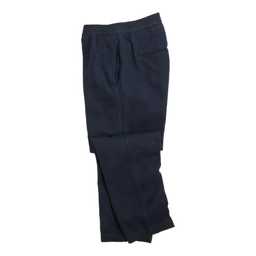 Marineblau herringbone broek opgerold op een witte achtergrond