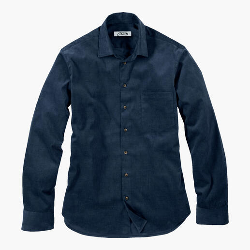 Donkerblauwe corduroy overhemden van Fashion Charts, gevouwen en op een tafel gelegd.