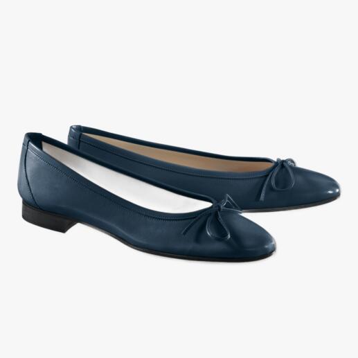 Navy ballerina's met strik op een lichte achtergrond.