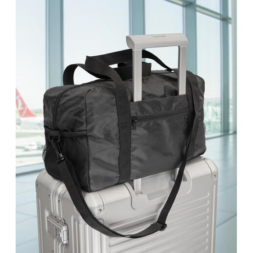 Exclusieve opvouwbare reistas op een koffer in de luchthaven.