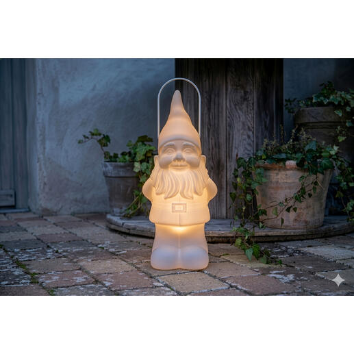 LED tuinkabouter met zacht licht, geplaatst op een stenen vloer naast plantenpotten.