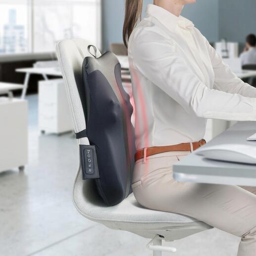 Rugmassageapparaat bevestigd aan een bureaustoel terwijl iemand werkt.