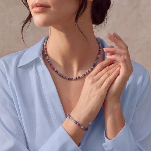 Vrouw draagt een Chamäleon sieradenset met een ketting en armband van kleurrijke kralen.