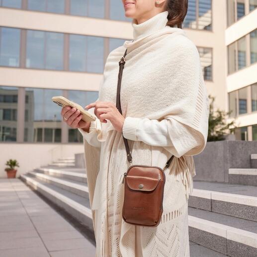Vrouw draagt een Chiarugi 2-in-1 smartphone tas over haar schouder tijdens een wandeling.