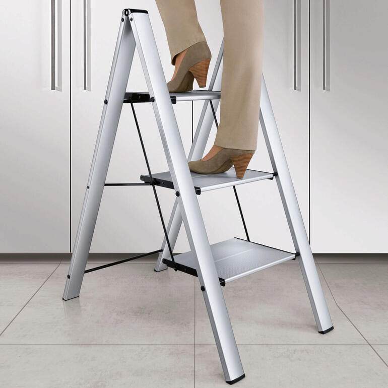 Italiaanse aluminium ladder met een voet op de tweede trede.
