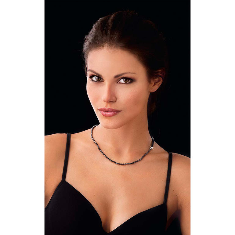 Vrouw met Black & Black spinelketting in een elegant outfit.