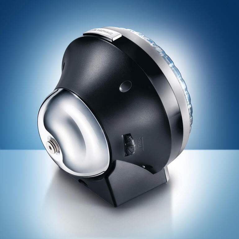 De klassieke klok op de achterzijde. Een mooie herinnering aan lang vervlogen tijden … Stijlvolle analoge wekker met verlicht uurwerk op blauwe achtergrond.