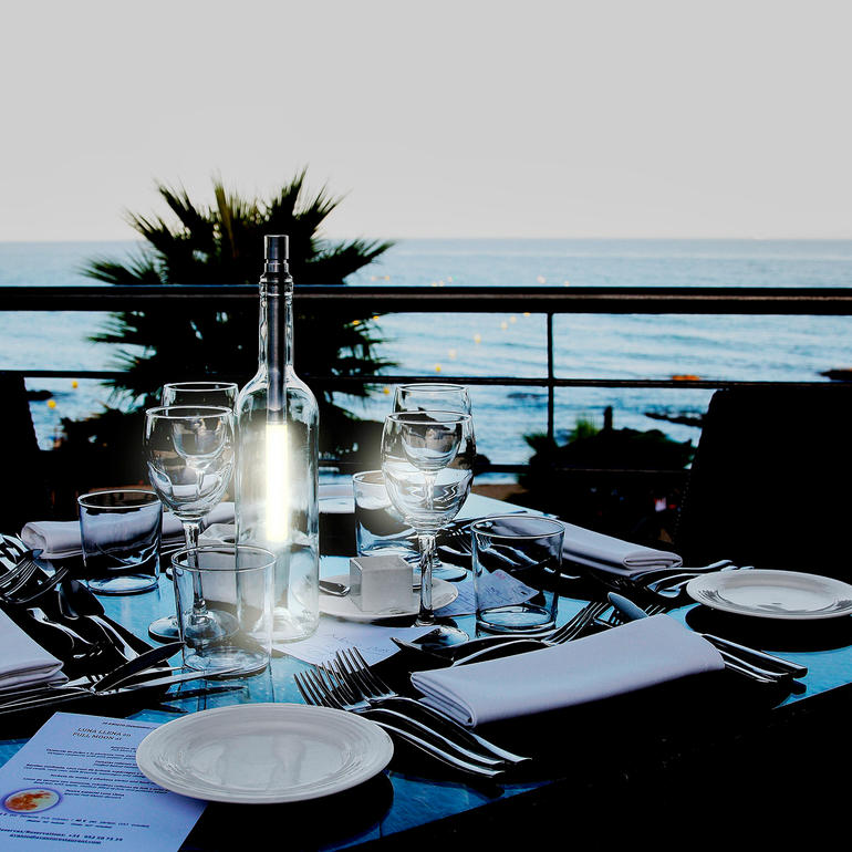 Glazen fles op een tafel met uitzicht op de zee.
