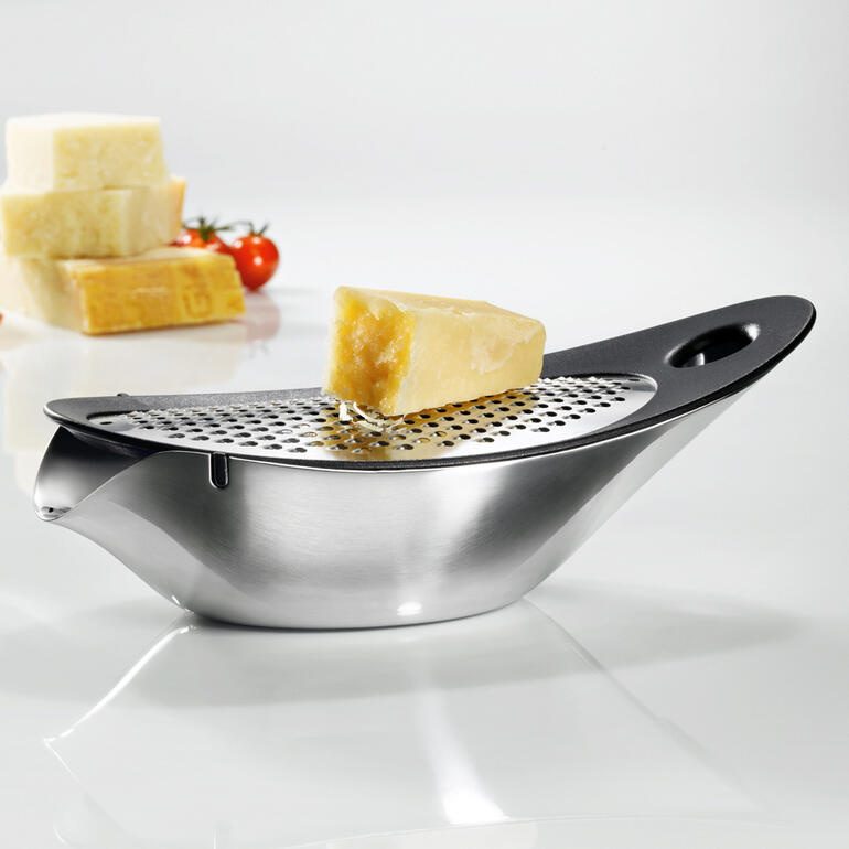 blomus® design-kaasrasp met kaasblokjes op een tafel.