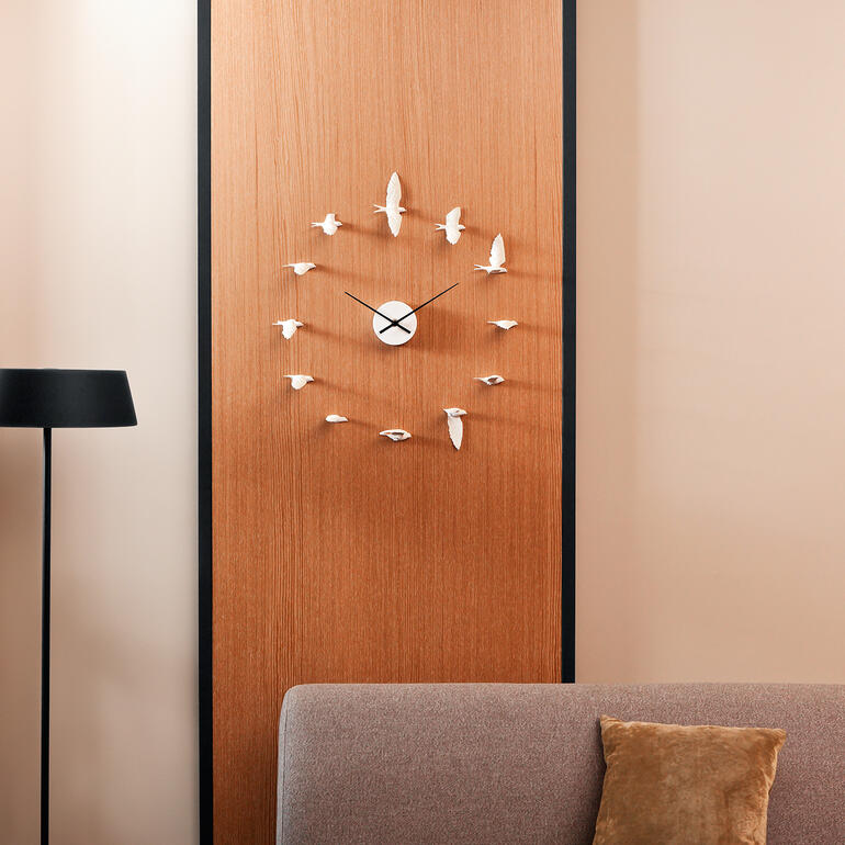 Zwaluw-klok aan een houten muur boven een bank.