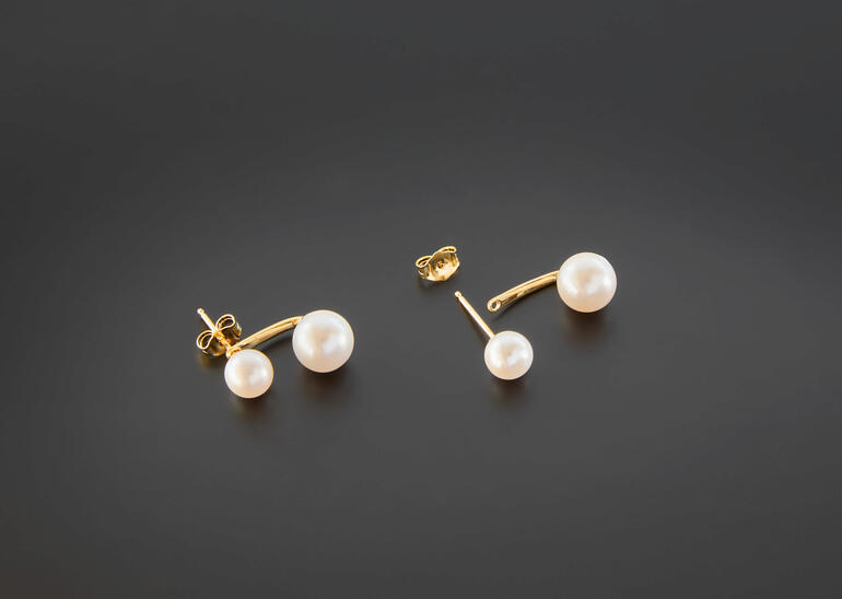 Twee oorbellen met zwevende parels in verguld zilver.