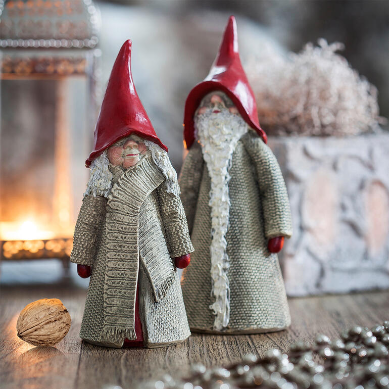 Twee Zweedse kerstgnomen met rode hoeden staan decoratief.