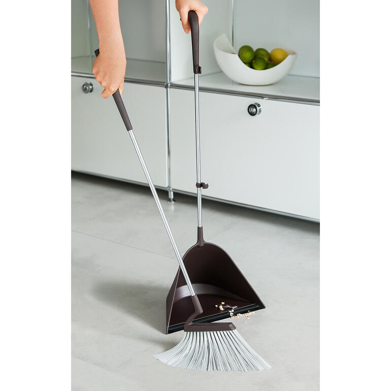 Asymmetrisch aangebrachte borstel met langere haren voor – zo wordt vegen extra comfortabel. Persoon met TIDY bezemset die de vloer veegt in een moderne ruimte.