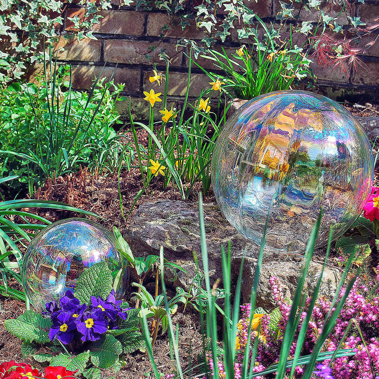 Twee zeepbellen in een bloeiende tuin met kleurrijke bloemen