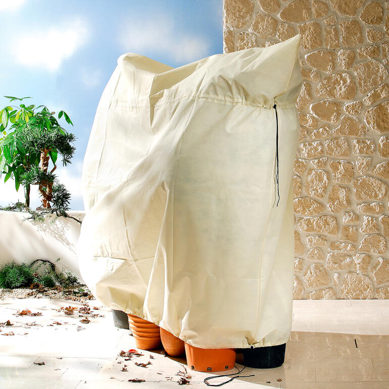Beschermhoes voor planten van beige materiaal.