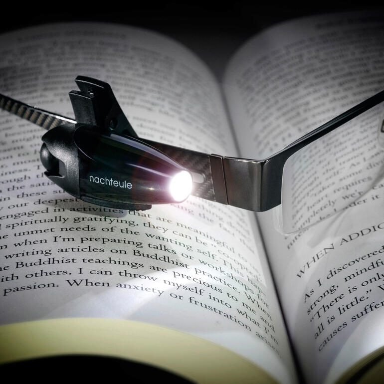 Cliplamp met ingebouwde LED-verlichting boven een open boek.