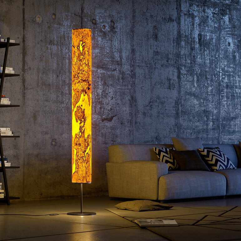 Houten lamp naast een bank in een moderne ruimte.