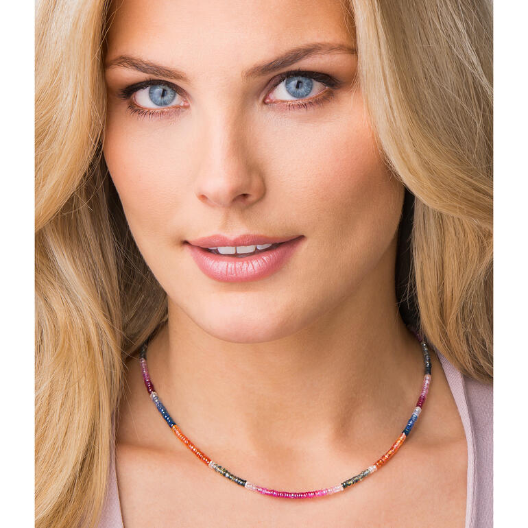 Vrouw draagt de saffierketting, met de focus op haar gezicht.