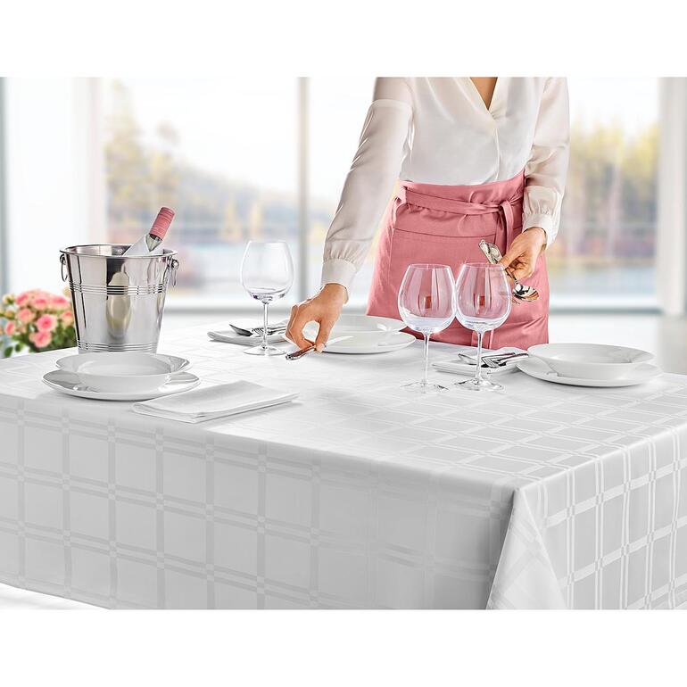 tafelkleed, wit Vrouw dekt een tafel met een vlekbestendig tafelkleed en glazen.