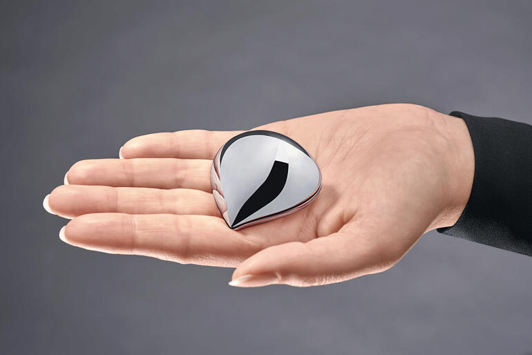 Alessi pillendoos in de vorm van een druppel in een hand