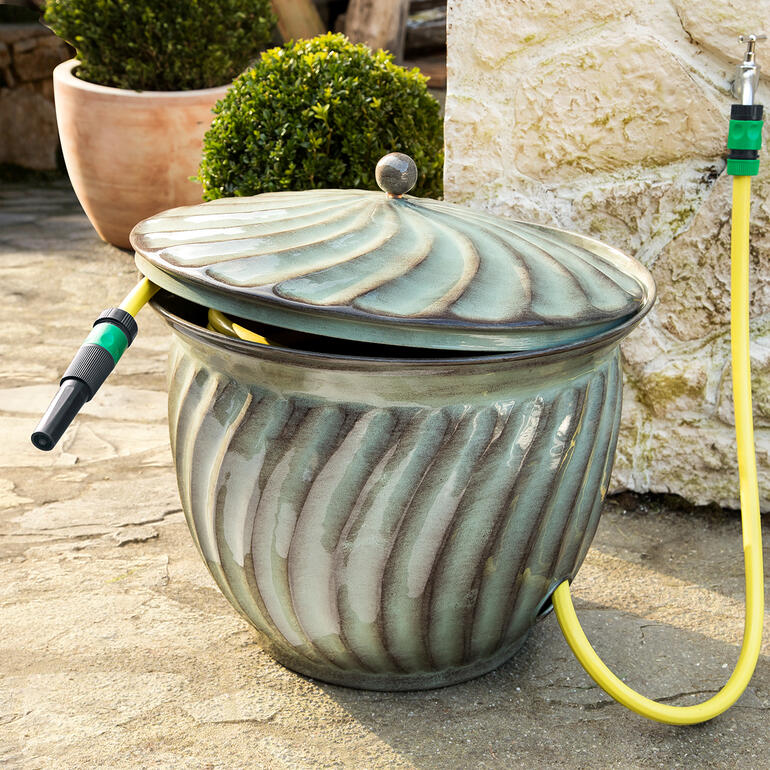 Elegante, ronde emmer met slang voor tuinirrigatie.
