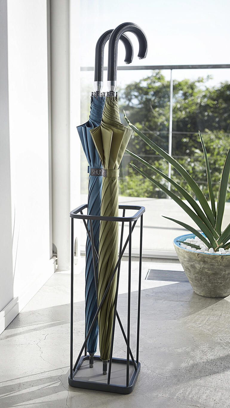 Standaard met verschillende paraplu's, elegant in een lichte kamer.