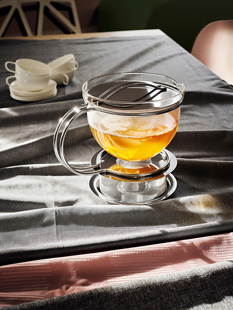 1,5 l theekan ‛Filio’ met warmhouder Theepot op tafel met kopjes en glazen.