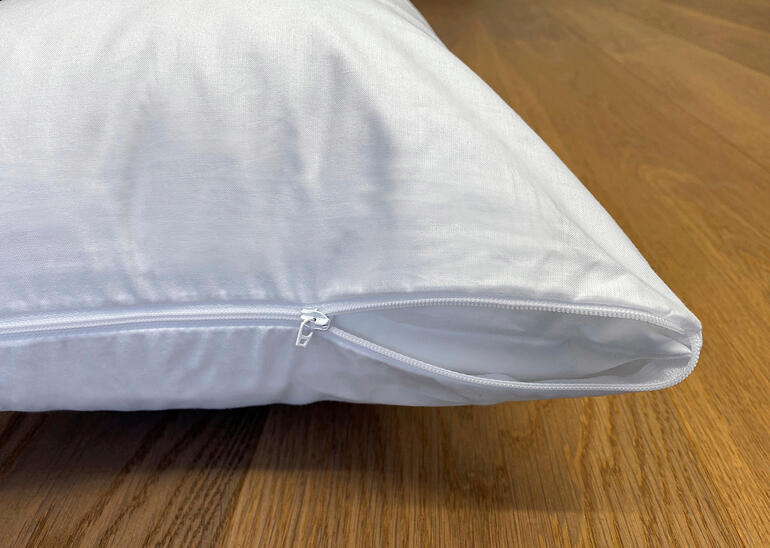 Kussenhoes met rits op een houten vloer.