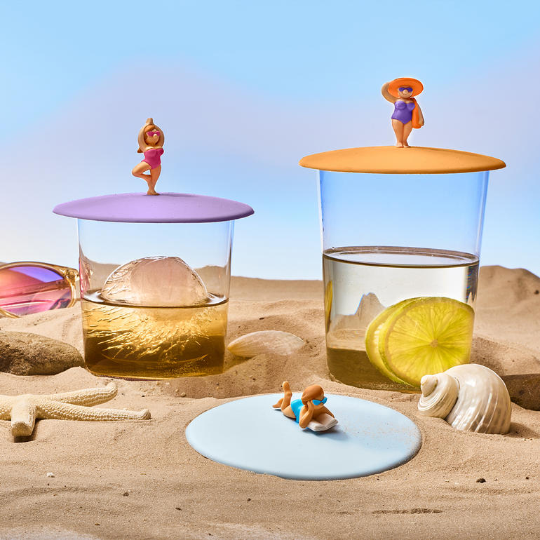 Twee glazen deksels met dranken en een strandthema.