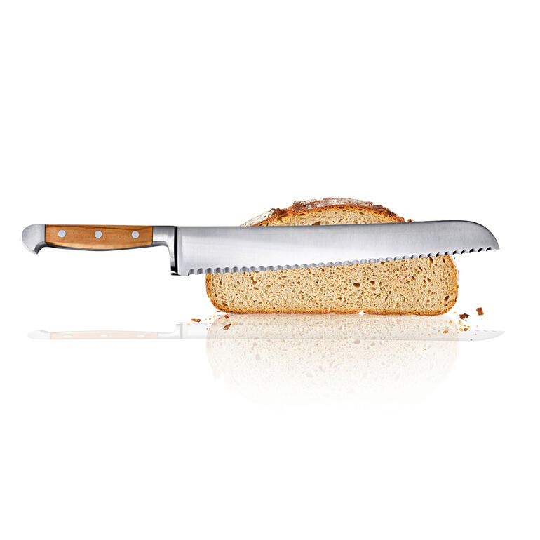 Broodmes met houten handgreep en gekartelde lemmet naast een sneetje brood.