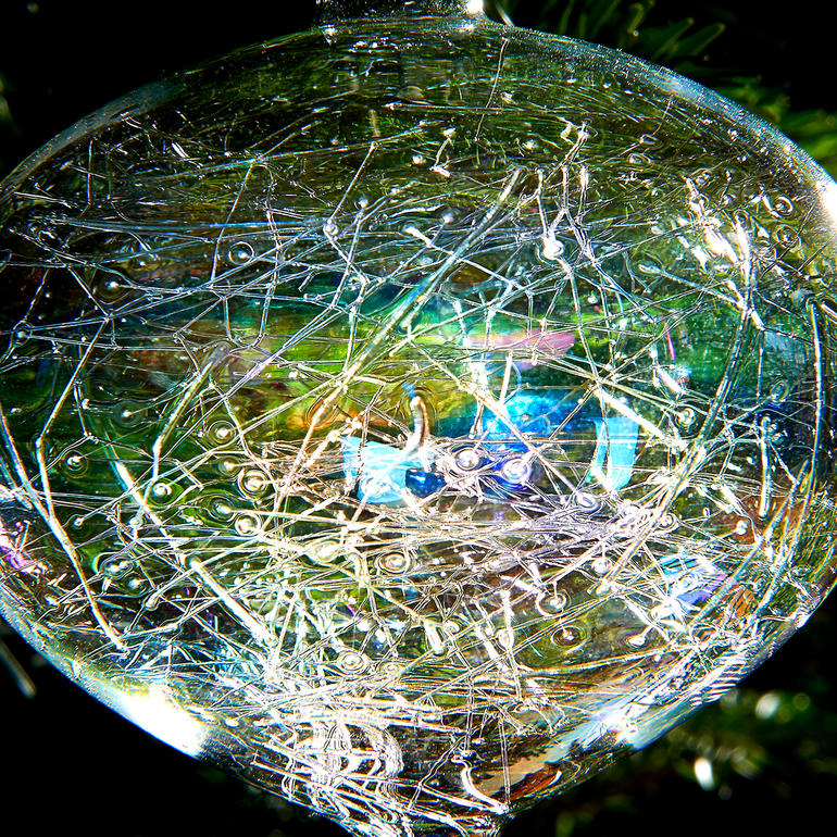 Iriserende glazen kerstboomversiering, 6-dlg. set Close-up van een glazen kerstbal met iriserende draden op het oppervlak.