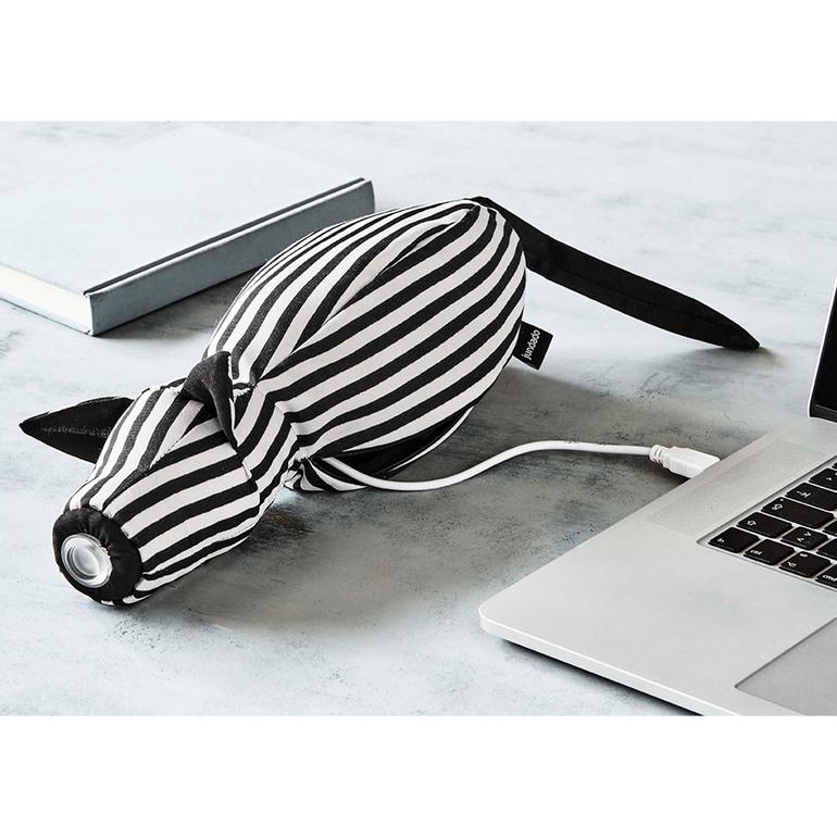 Eenvoudig op te laden via USB-oplaadkabel (meegeleverd). Leeslamp in de vorm van een gestreepte dierenfiguur, op een tafel met een laptop en een boek.
