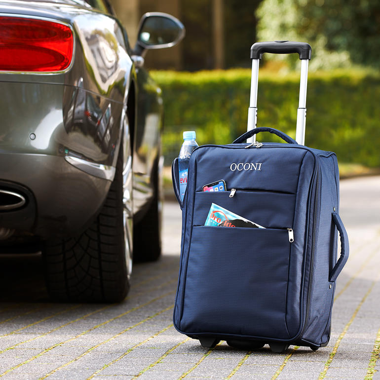 OCONI opvouwbare trolley in donkerblauw met wielen, waterfles en tijdschriften in de tas.