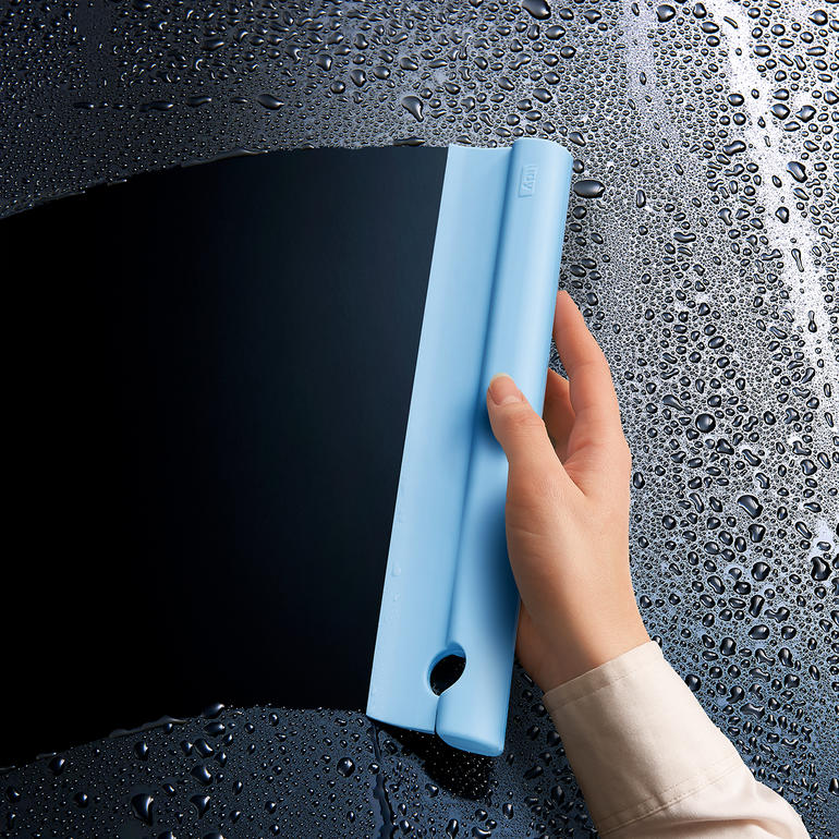 Siliconen douchetrekker in blauwe kleur, vastgehouden in de hand